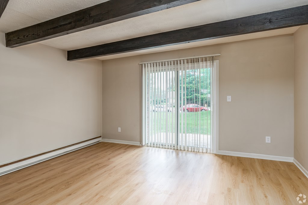 A room with wooden floors and a sliding glass door.
