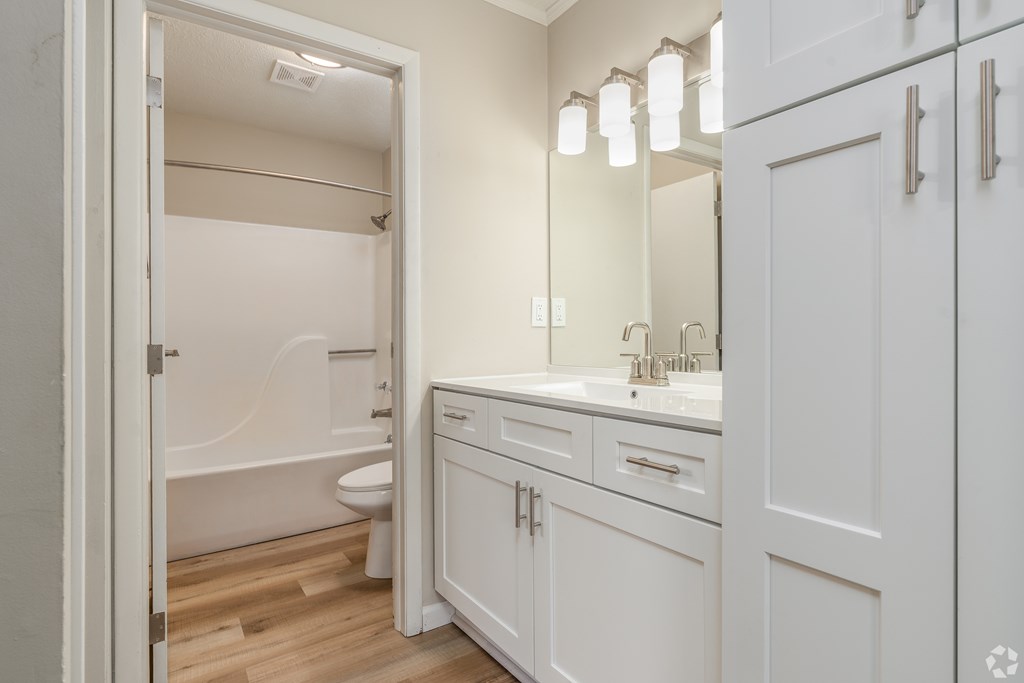 A white bathroom with a tub, toilet, and sink.