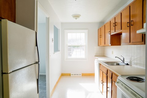 an empty kitchen with a refrigerator and a sink