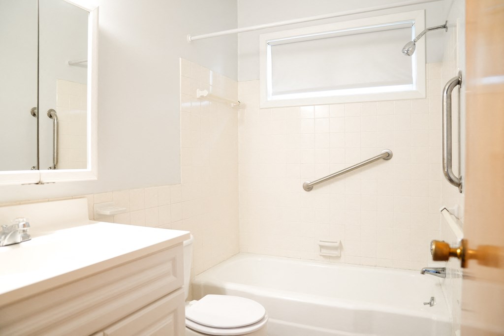 a white bathroom with a tub and a sink and a toilet