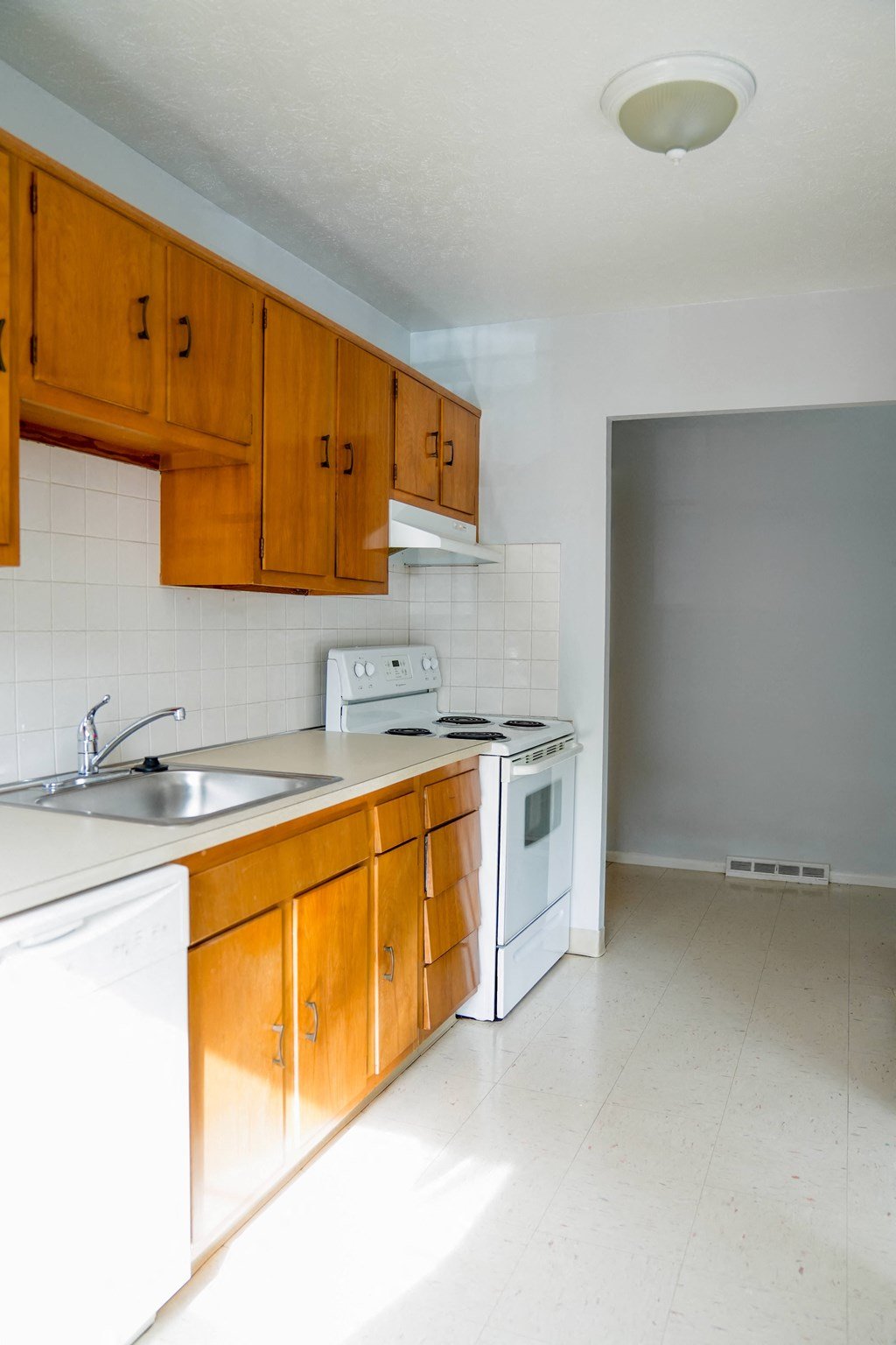 a kitchen with white appliances and wooden cabinets
