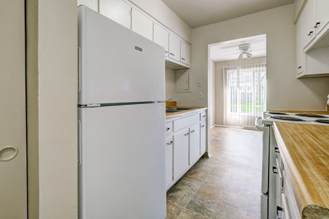 a kitchen with white cabinets and a white refrigerator