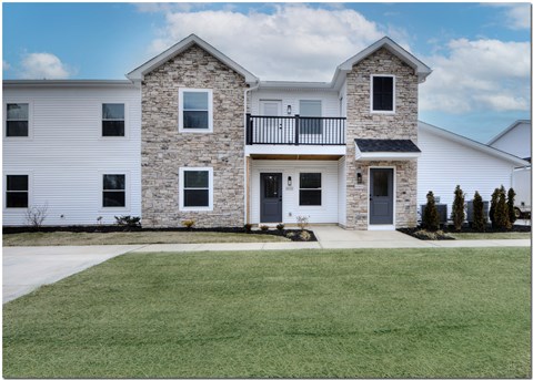 an image of a white house with a yard and a balcony