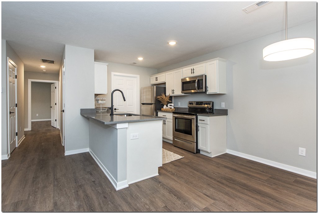 a kitchen with white cabinets and a counter top
