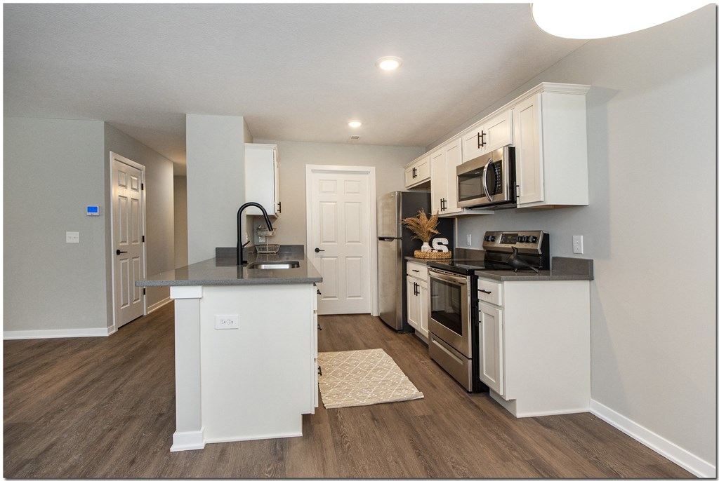 a kitchen with white cabinets and stainless steel appliances