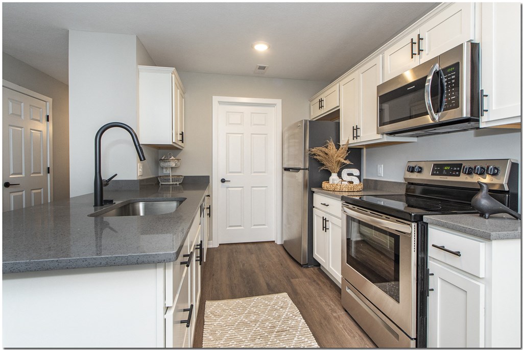 a kitchen with stainless steel appliances and white cabinets