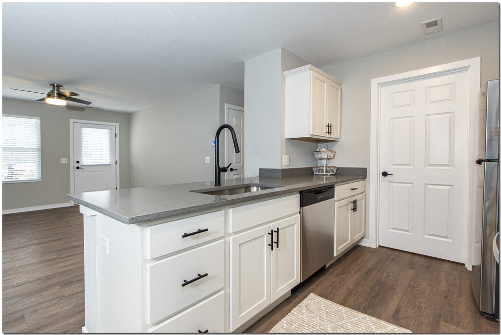 a kitchen with white cabinets and a sink and a refrigerator