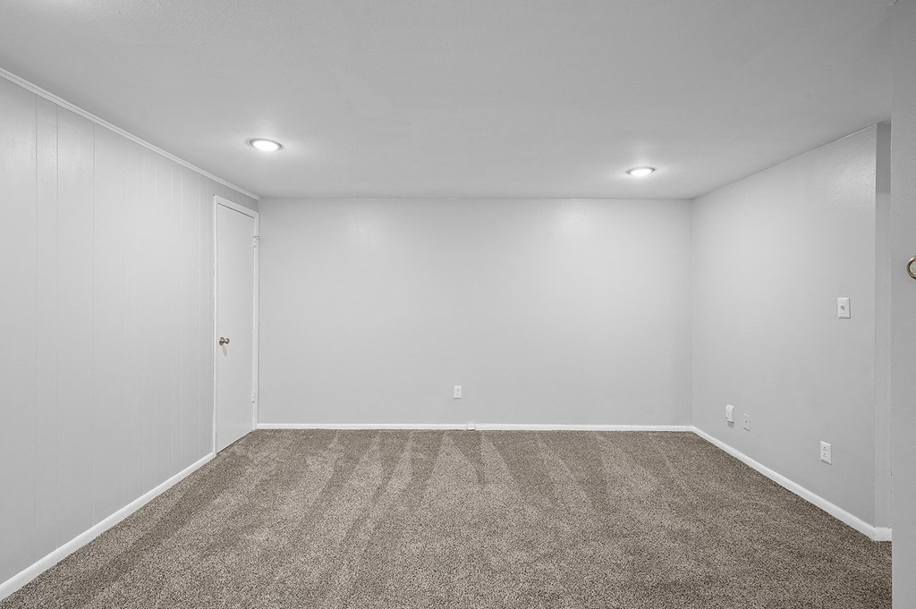 an empty room with carpet and white walls