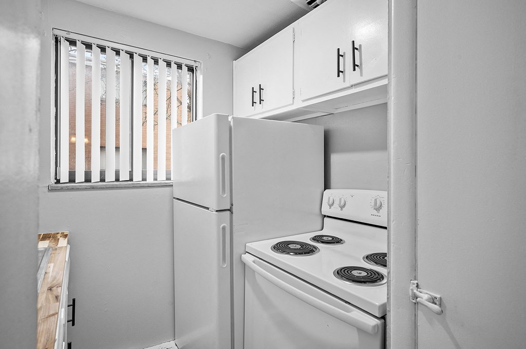a white kitchen with white appliances and white cabinets