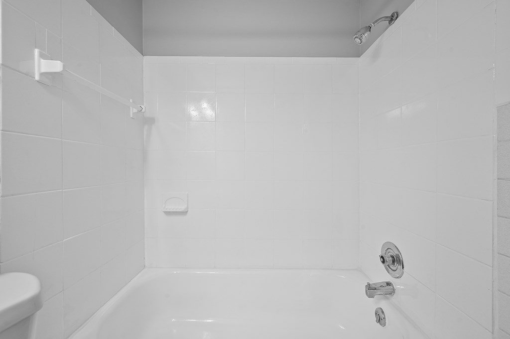 a white bathroom with a tub and a sink