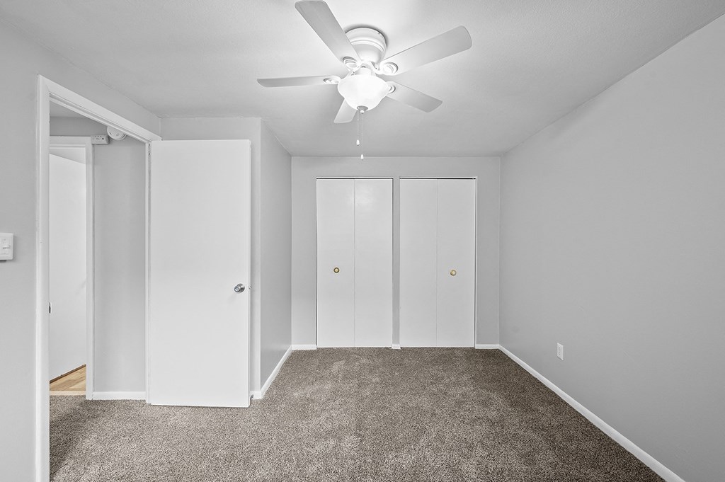 a room with carpet and a ceiling fan