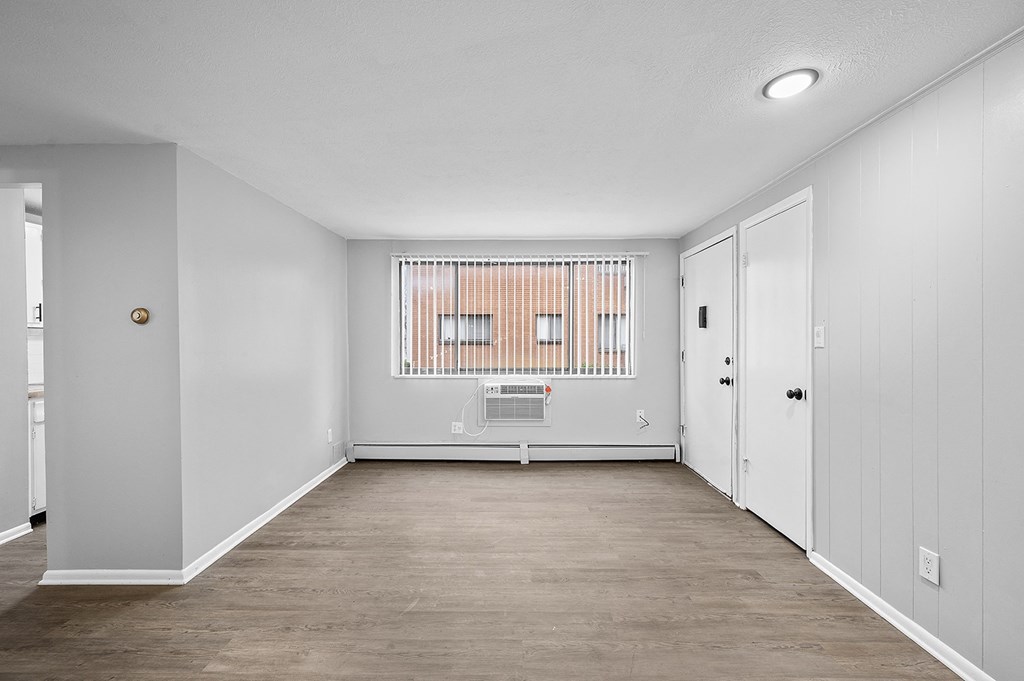 an empty room with white walls and a window