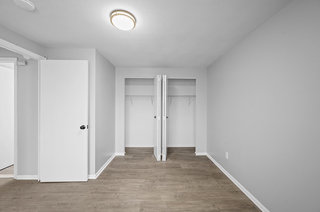 an empty room with white walls and white doors and a wood floor
