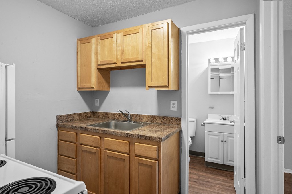 an empty kitchen with wooden cabinets and a sink