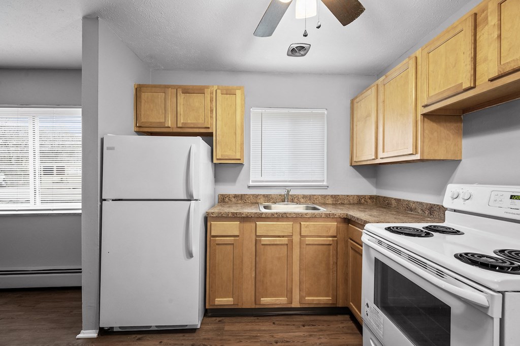 a kitchen with white appliances and wooden cabinets