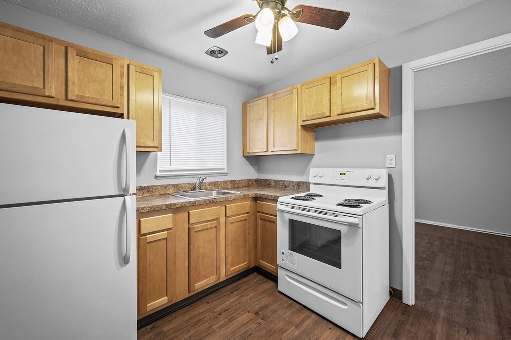a kitchen with white appliances and wooden cabinets