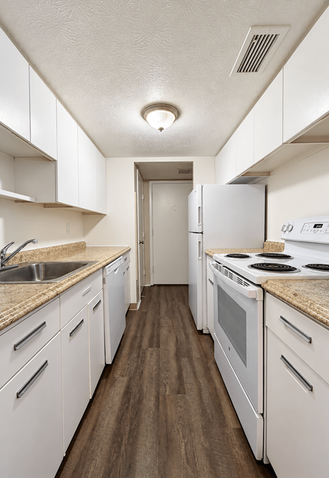 A kitchen with white cabinets and appliances.