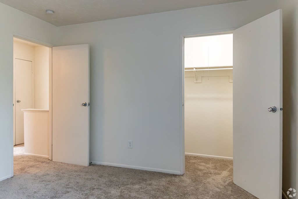 an empty bedroom with a closet and a window