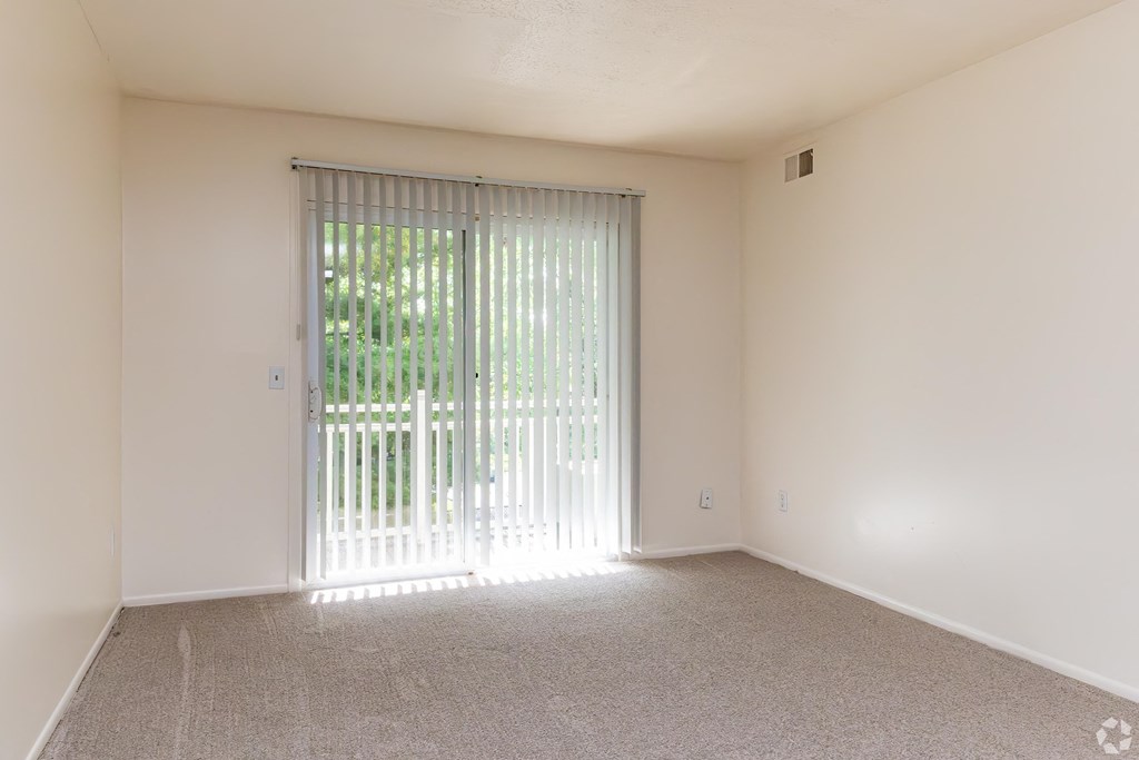 the living room of an empty apartment with sliding glass doors