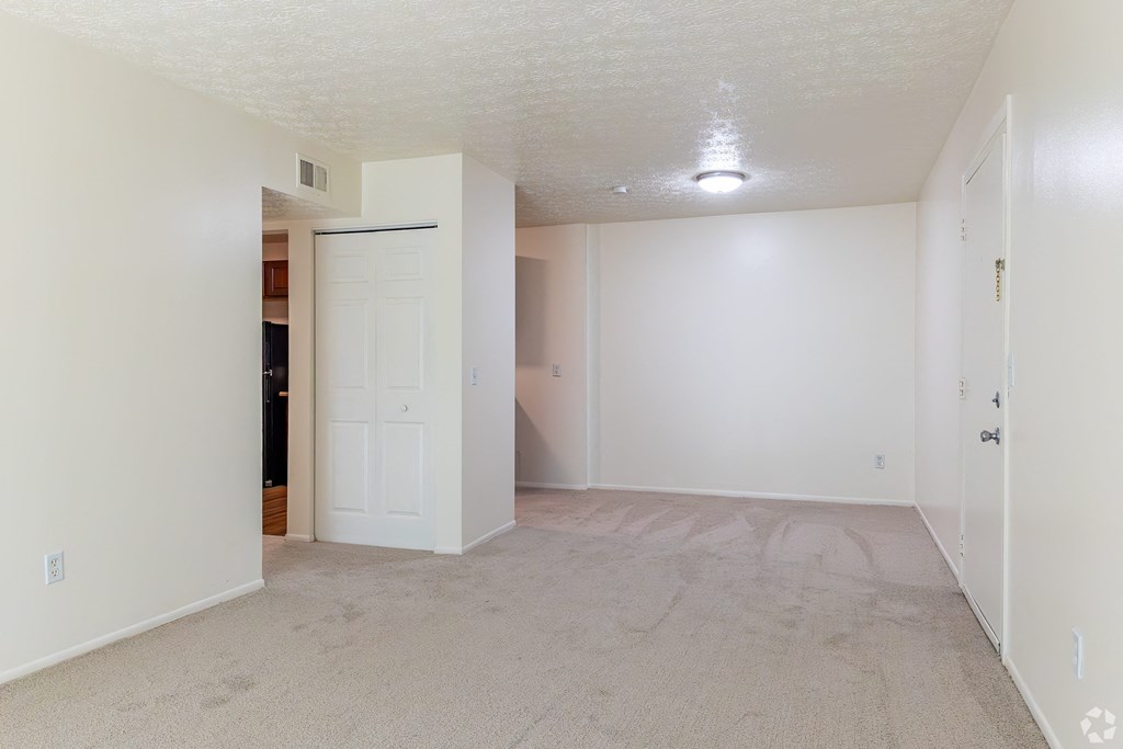 an empty living room with white walls and a white door