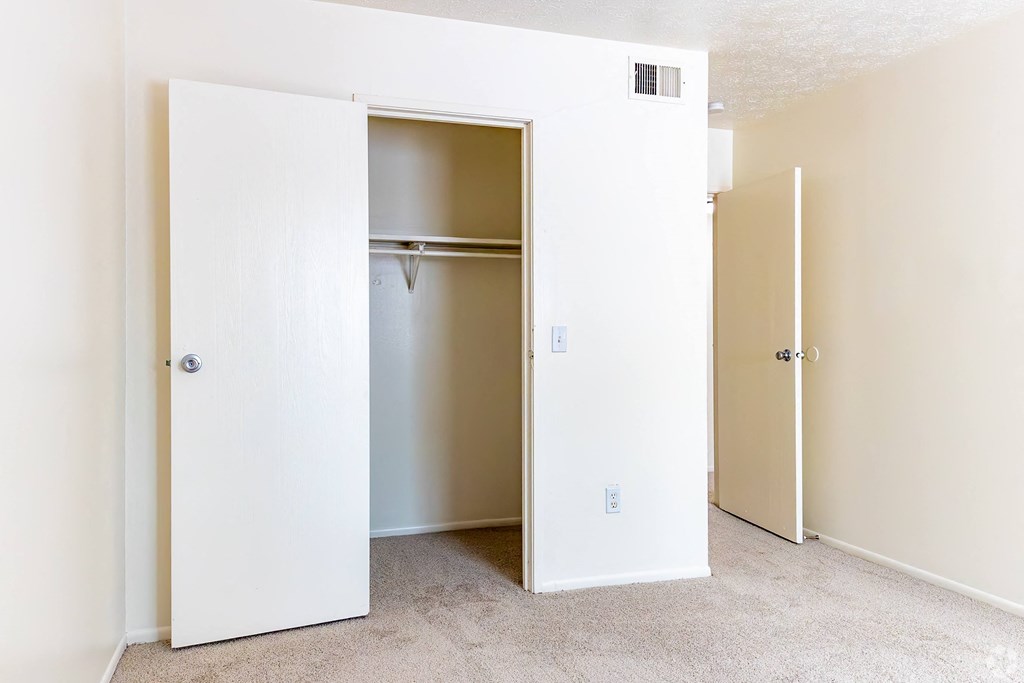 an empty closet in a room with a door open