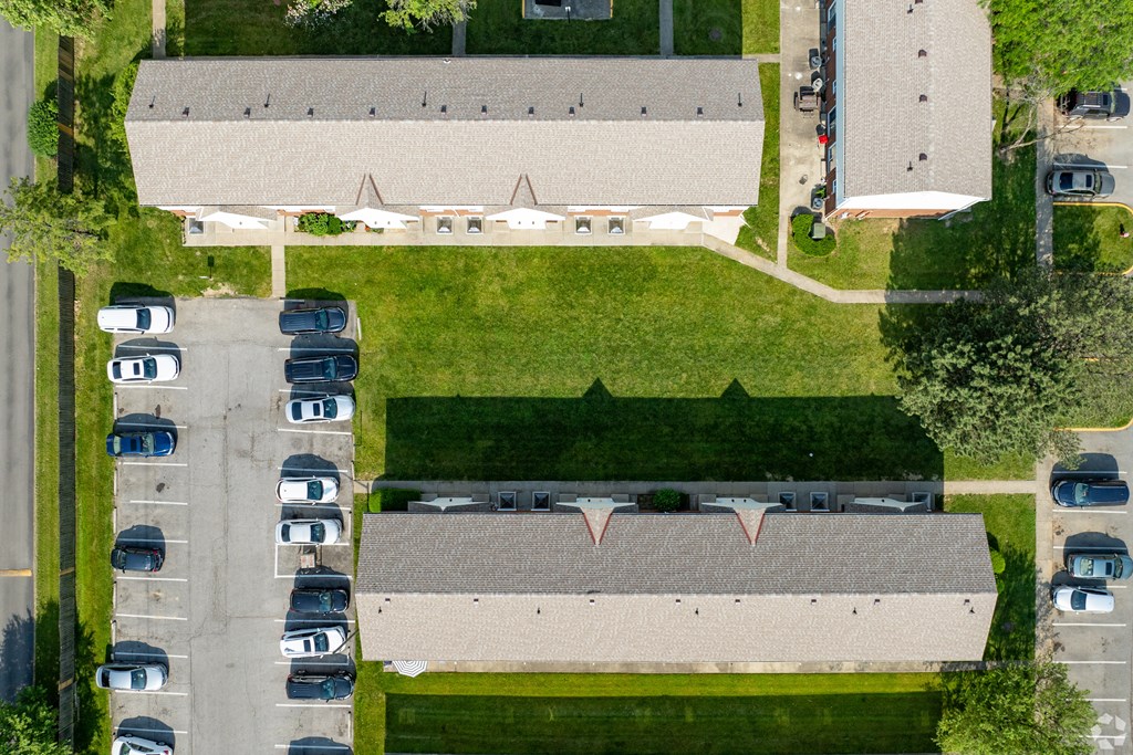 an aerial view of a parking lot and a building with cars parked