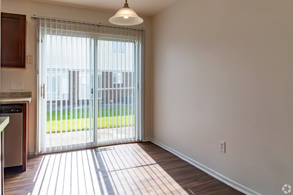an empty living room with sliding glass doors to a yard