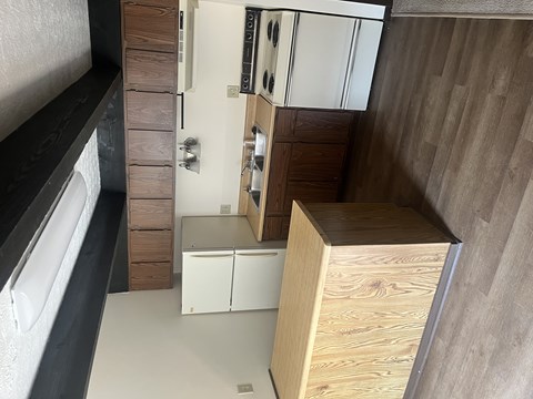 A kitchen with wooden cabinets and a white fridge.