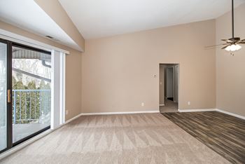A room with a carpeted floor and a ceiling fan.