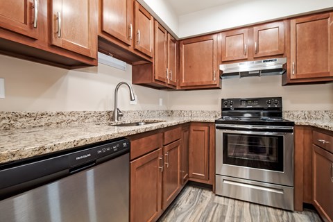 A kitchen with wooden cabinets and a granite countertop.
