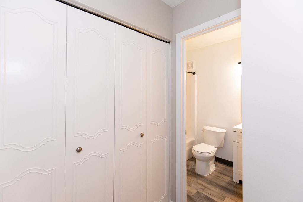 a bathroom with white closets and a toilet in it