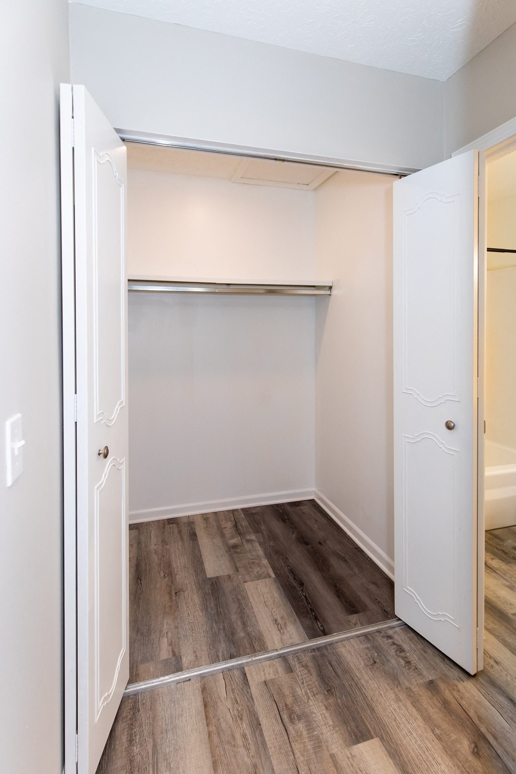 an empty bedroom with a closet and a wood floor