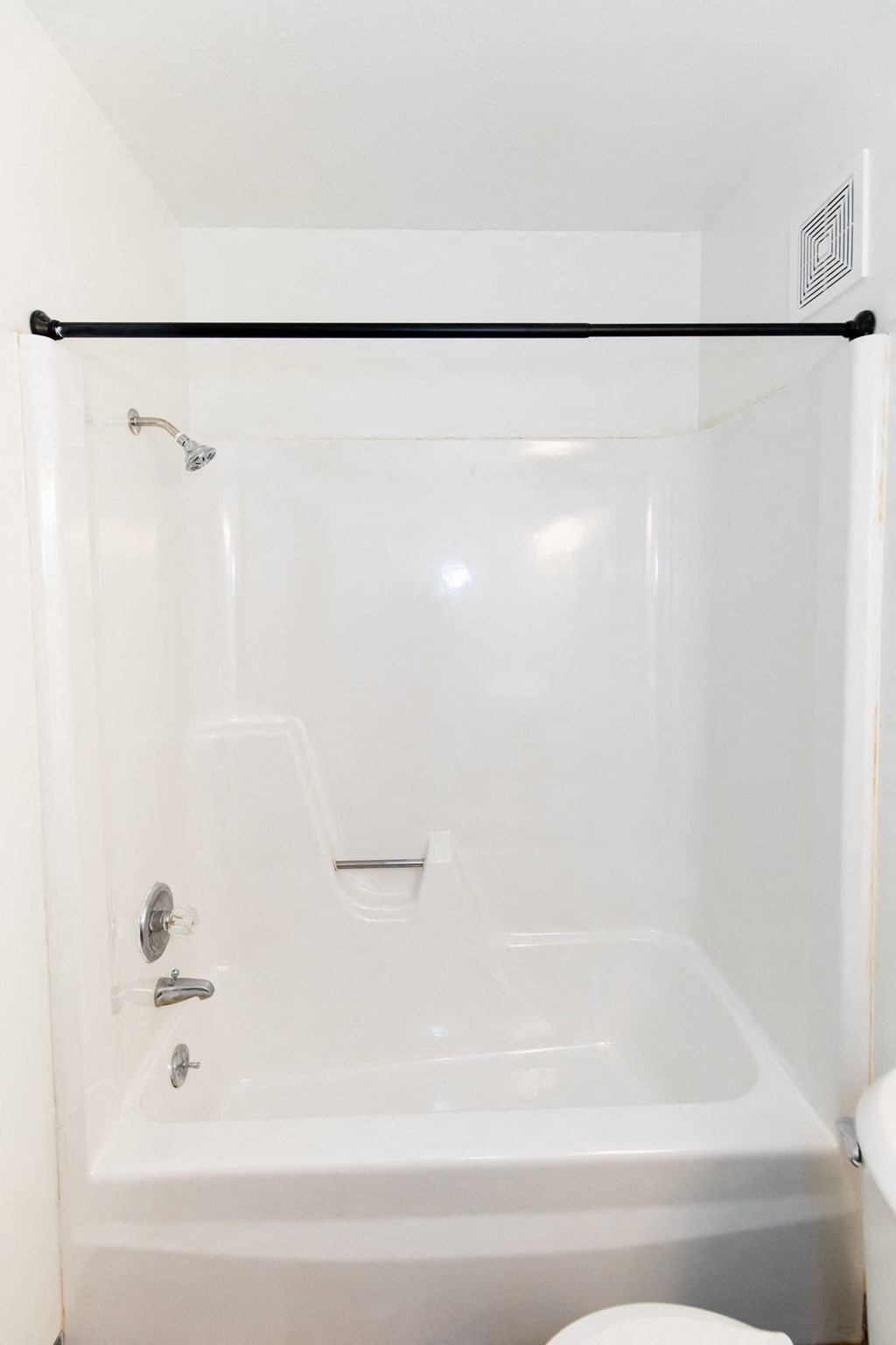 a white bathroom with a shower and a toilet