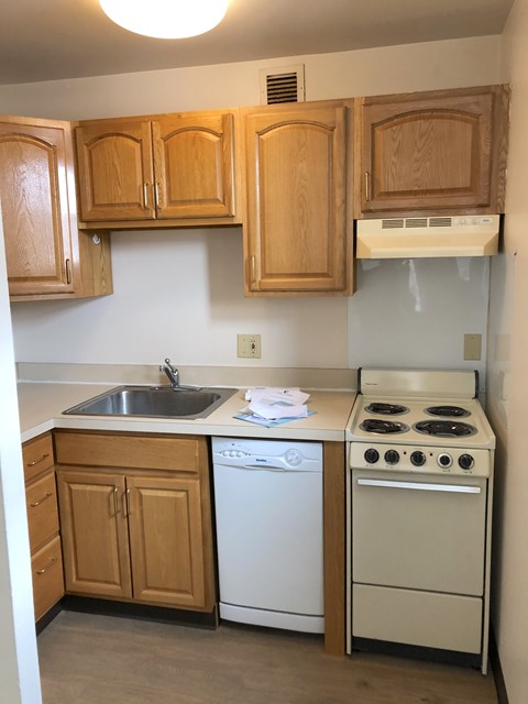 A small kitchen with a white dishwasher and a white stove.
