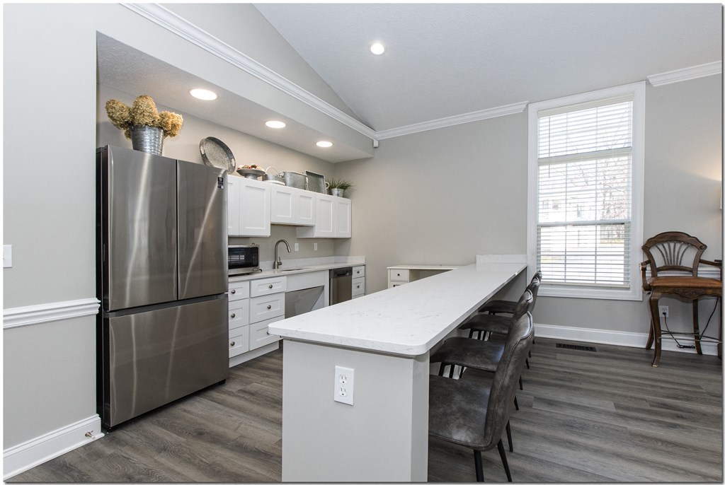a kitchen with a large island and stainless steel appliances