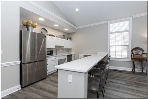 a kitchen with a large island and stainless steel appliances