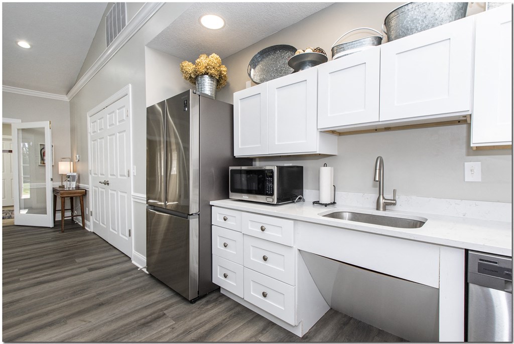 a kitchen with white cabinets and stainless steel appliances