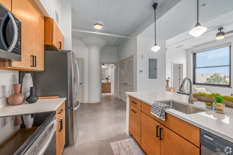 A kitchen with wooden cabinets and a black refrigerator.