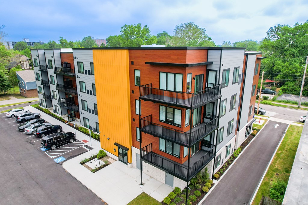 A modern apartment building with a parking lot in front. at The Lumos Apartments, Ohio, 44106