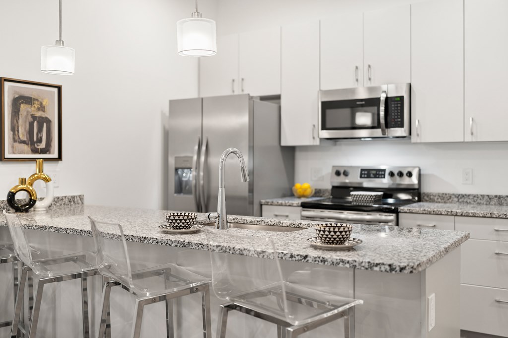 A kitchen with a granite countertop and stainless steel appliances. at The Lumos Apartments, Cleveland, OH, 44106