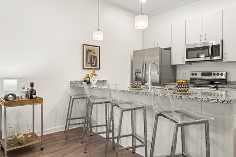 A kitchen with a white counter top and stainless steel appliances.