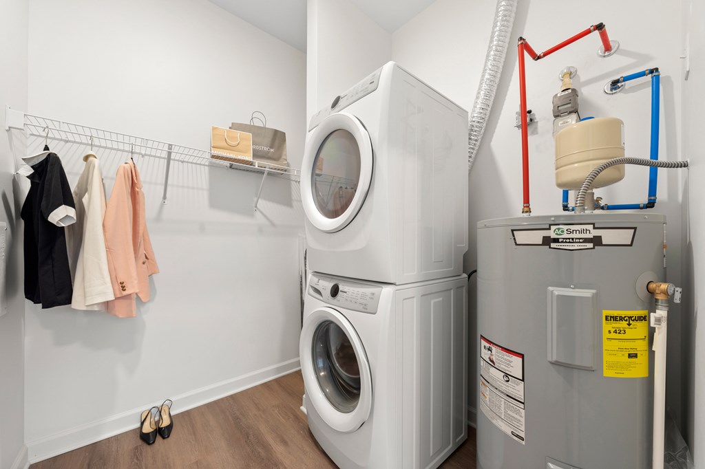 A washing machine and dryer in a small laundry room. at The Lumos Apartments, Cleveland, OH