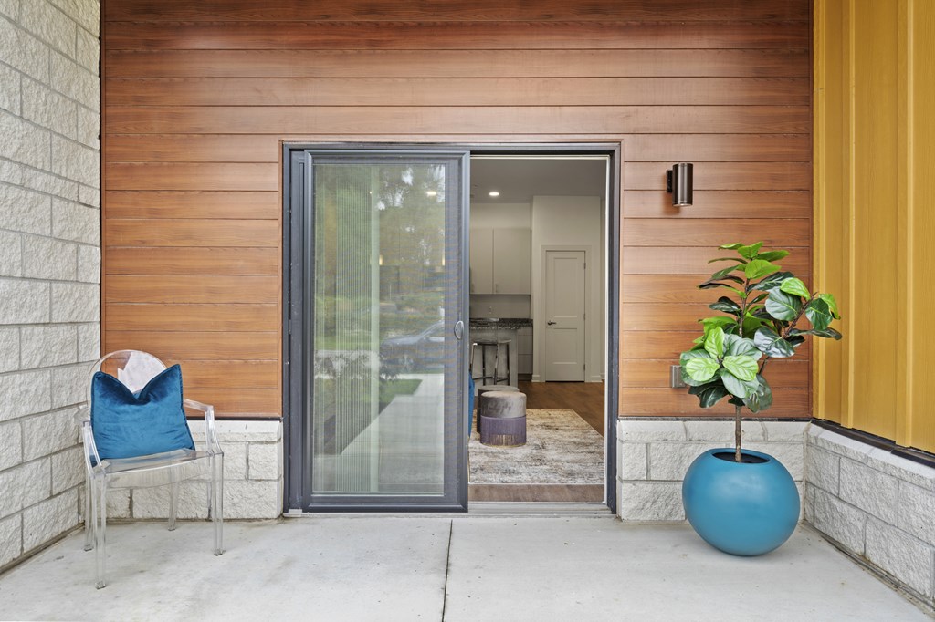 A blue chair with a white pillow is on the porch of a house. at The Lumos Apartments, Cleveland, OH, 44106