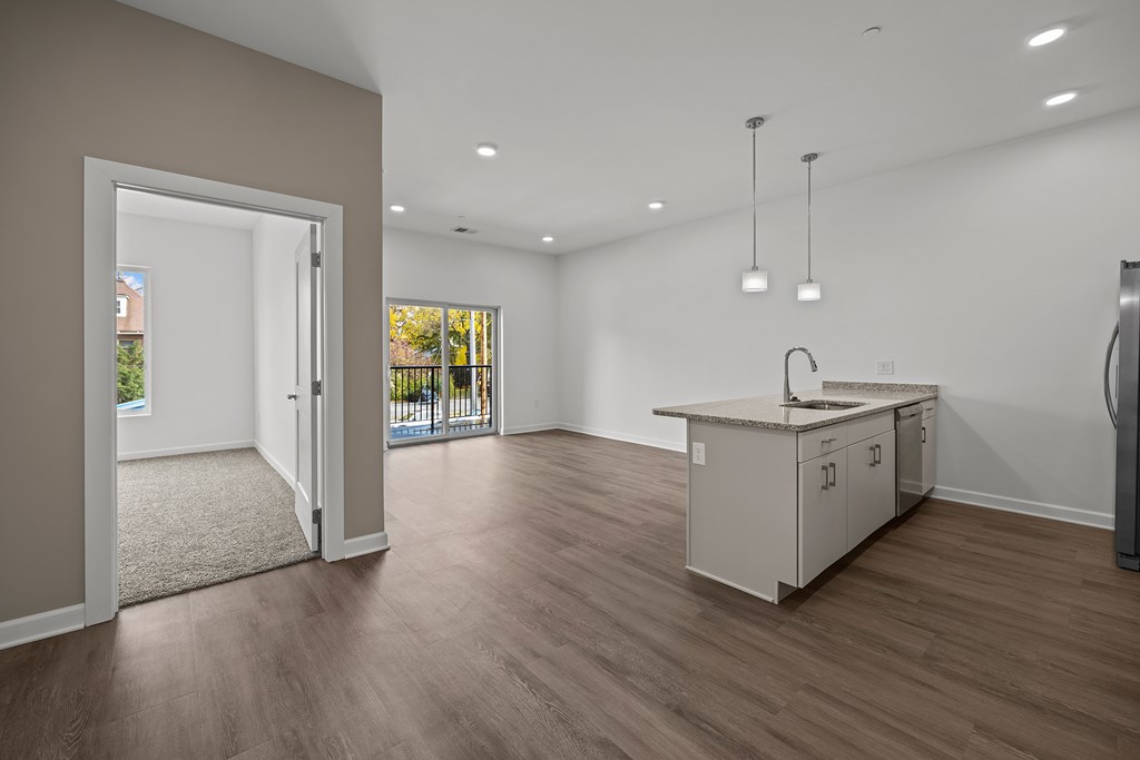 A kitchen area with a sink, cabinets, and a refrigerator. at The Lumos Apartments, Ohio, 44106
