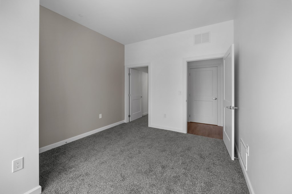 A room with a carpeted floor and two doors. at The Lumos Apartments, Ohio, 44106