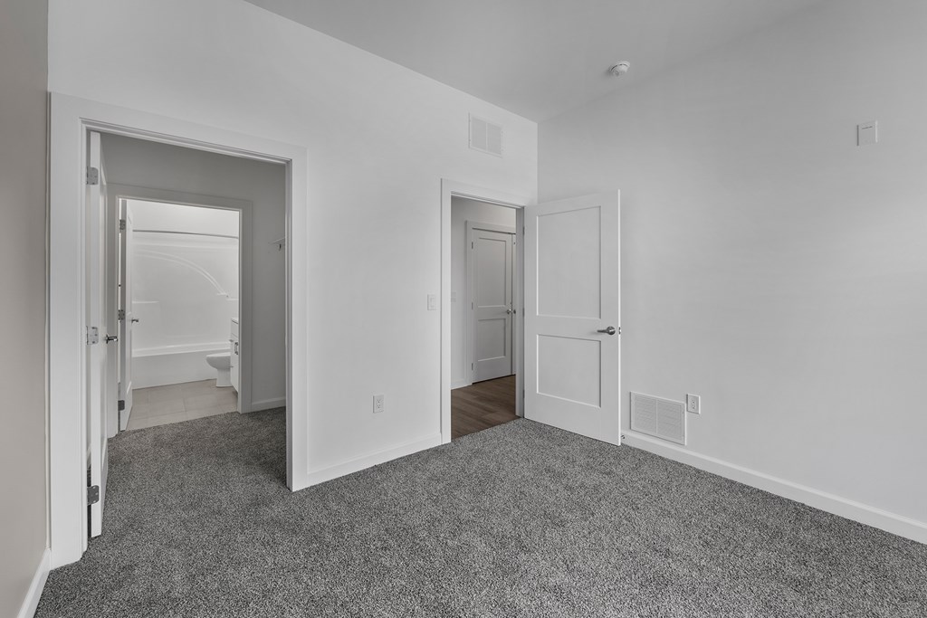 A room with two doors and a carpeted floor. at The Lumos Apartments, Cleveland, OH, 44106