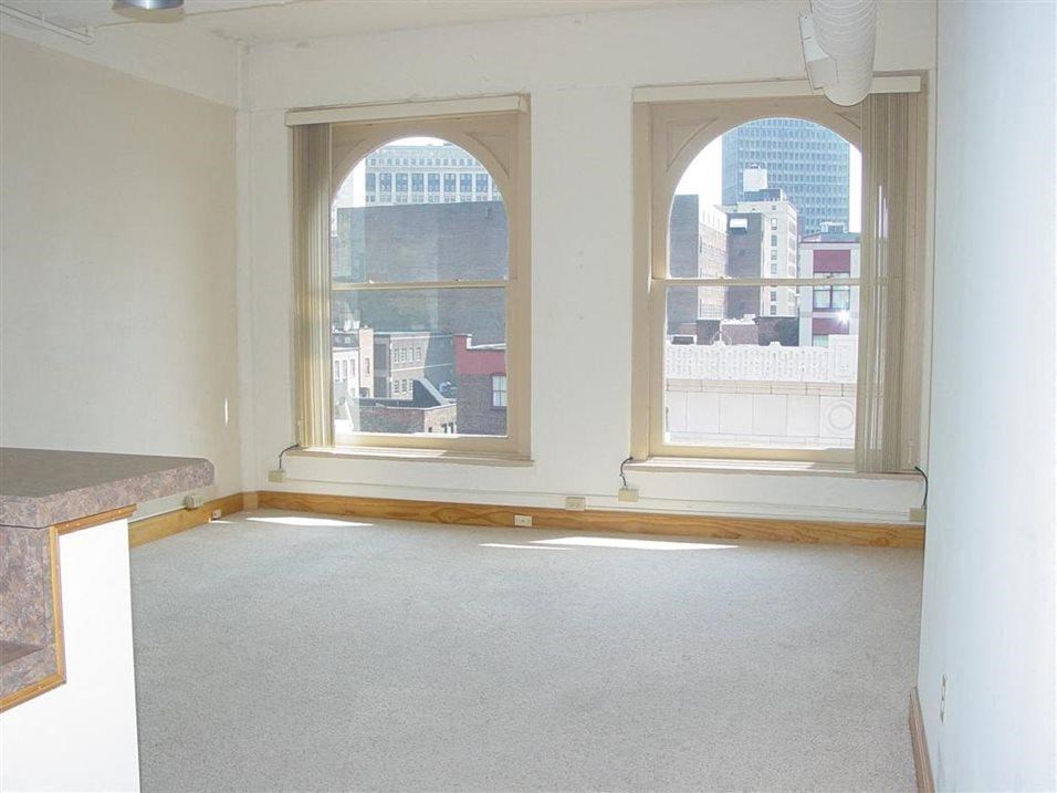 an empty room with three large windows