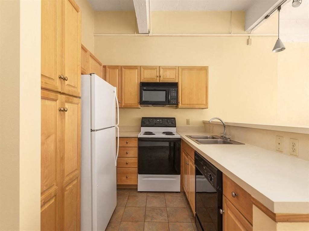 a kitchen with a white counter top and a black and white stove top oven