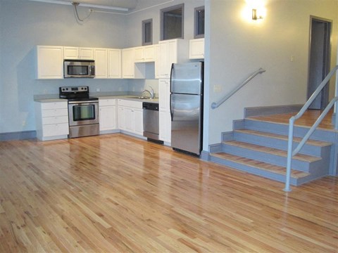 a kitchen with stainless steel appliances and a wooden floor