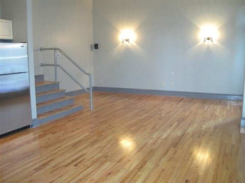 a large room with a wooden floor and stairs